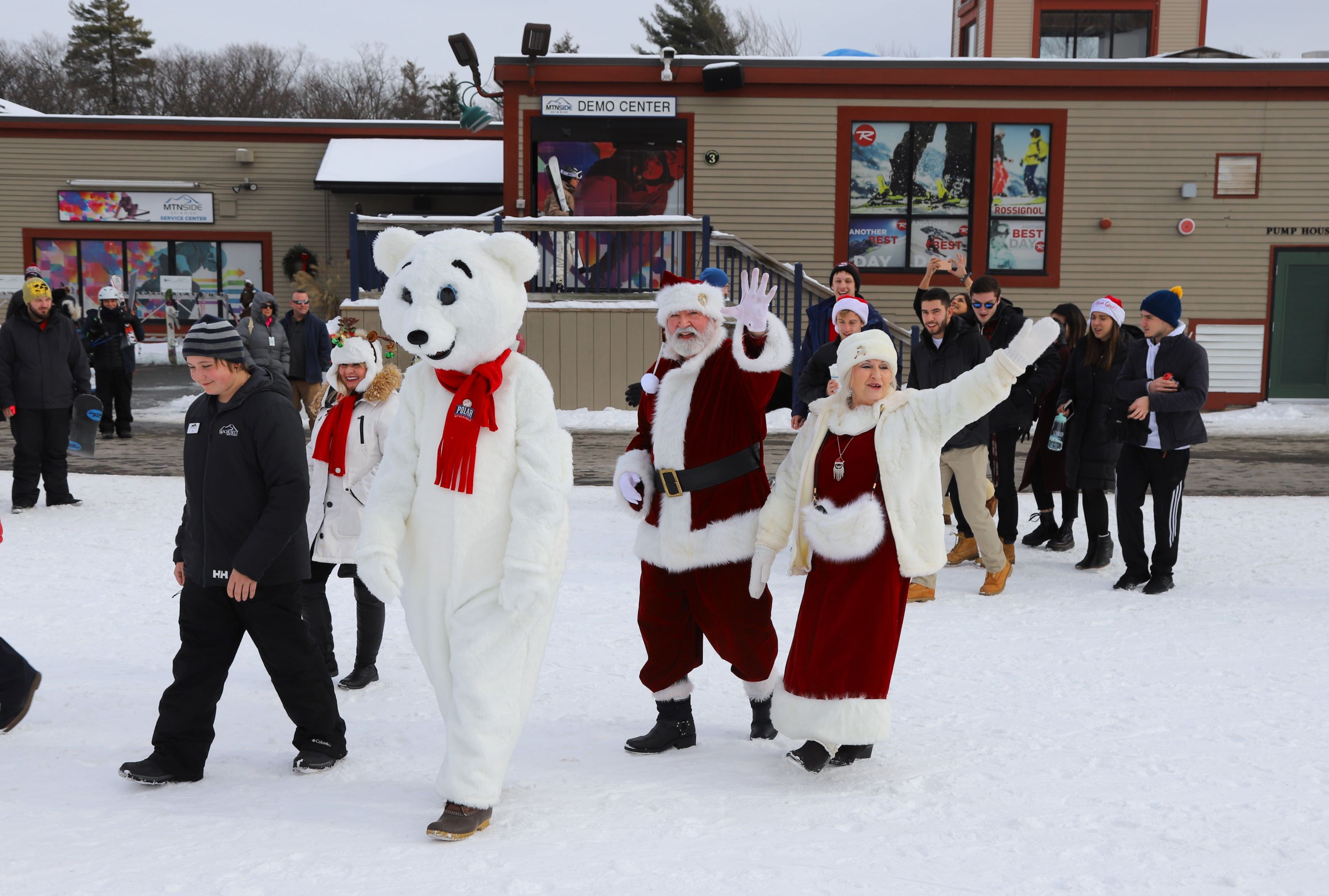 Santa and Mrs. Claus walk with Orson the Polar Bear on snow